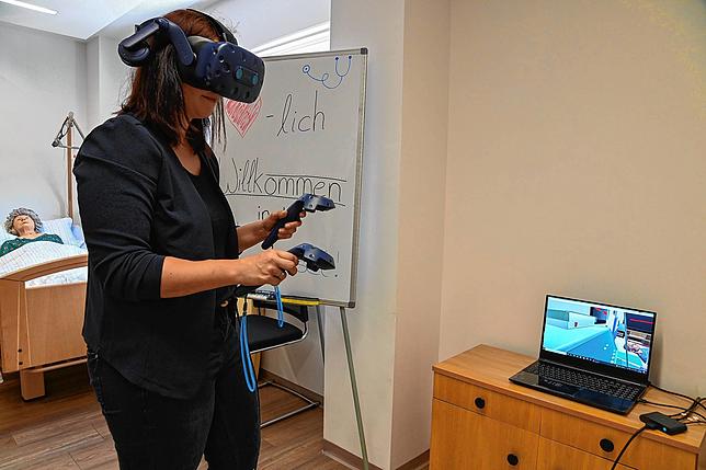 Frau mit VR-Brille und Controllern im CyberCareLab