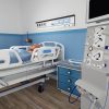 Abbildung einer Person in einem Krankenbett in VR, welche mit Kathetern an eine Maschine angeschlossen ist